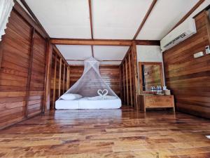 库德岛丛林沽岛度假村 的木制客房内的一间卧室,配有一张床