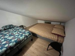 圣但尼Chez Polo的一间小卧室,配有两张床和椅子