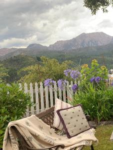 皇后镇彭哈纳住宿加早餐酒店的坐在花园的长凳上,围栏和鲜花
