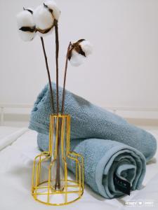 诗巫Hanns&FreeWiFi&Washer&Parking &Pool&Sauna&Sunshine Comfort Homstay2的毛巾边的花瓶里装着两朵花