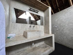 姆托瓦姆布The Jungle Pearl Resort的石质浴室设有水槽和镜子