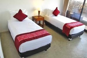 BaliboBalibo Fort Hotel的客房内的两张床和红色枕头