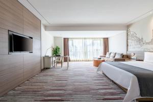 成都Chengdu Prolit Hotel的配有一张床和一台平面电视的酒店客房