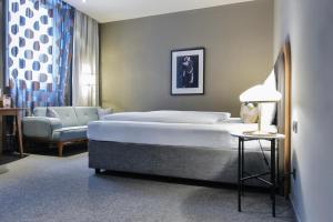维也纳Hotel George Vienna的一间卧室配有一张大床和一把椅子