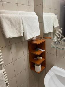 沙托劳尔尧乌伊海伊Hotel Hunor的浴室提供白色毛巾、水槽和镜子