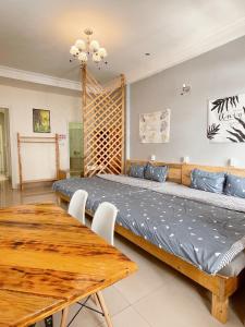大叻Da Lat Lemongrass - Đà Lạt Sả的一间卧室配有一张大床和一张木桌