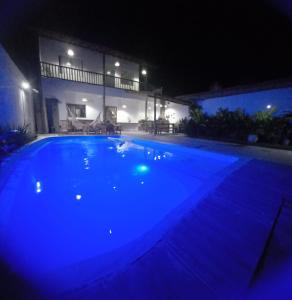 托兰克索Casa Versel Trancoso的夜间在房子前面的一个大型蓝色游泳池