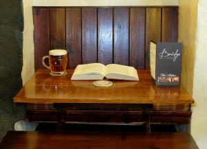 巴特米尔布里奇酒店的一张桌子,上面放着一本书,放着一杯啤酒