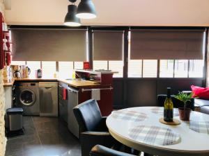 Corcelles-les-ArtsL'Aubergiste的一间带桌子的厨房和一间带桌椅的厨房