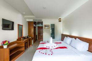 卡伦海滩班瓦尼达花园度假酒店的卧室配有红色色调的大型白色床