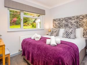 ApplethwaiteMerlestead的一间卧室配有一张大床和紫色毯子