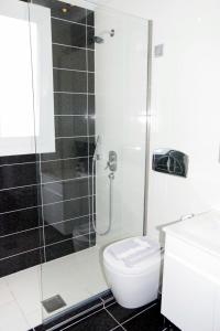 斯卡拉拉乔伊Rachoni Resort的带淋浴和卫生间的白色浴室