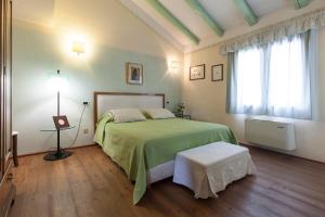 米拉诺COUNTRY HOUSE CASAMIRIAM的一间卧室设有一张绿色的床和一个窗户。
