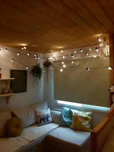 首尔Mapo Rooftop camping house的带沙发和弦灯的客厅