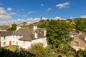 爱丁堡The Canongate Apartment的城市中一座带红色门的白色房子