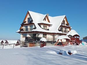 Gliczarów GórnySielanka w górach的雪中积雪覆盖的房子