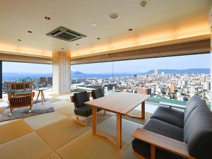 高松Yunaginoyu Hotel Hanajyukai的客厅设有桌子和大窗户