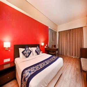 孟买The Legend Hotel- Santacruz Near Mumbai International Airport的一间卧室设有一张红色墙壁的大床