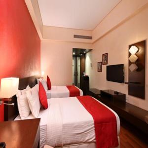 孟买The Legend Hotel- Santacruz Near Mumbai International Airport的酒店客房设有两张床和电视。