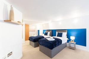 诺丁汉Crusader Apartment, Sleeps 7, Nottingham City Centre, FREE PARKING!的一间卧室设有两张床和蓝色的墙壁