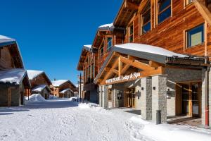 拉普拉涅CGH Résidences & Spas White Pearl Lodge的小屋前的一条雪覆盖的街道
