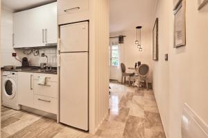 加的斯Little Sopranis Little Apartments的厨房配有白色橱柜和冰箱。