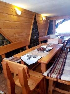 Białka TatrzanskaAgroturystyka u Marii的一间带木桌和长凳的用餐室