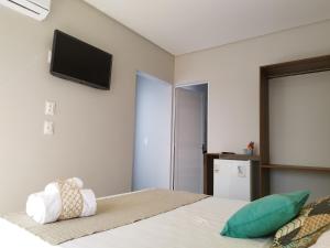 马拉戈日Bless的卧室配有一张壁挂式平面电视的床。