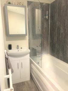 LongtownCumbria Reach的带淋浴、盥洗盆和浴缸的浴室