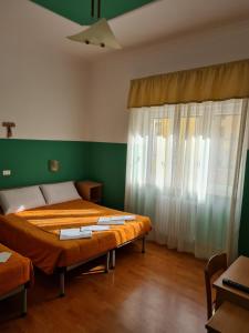 圣乔瓦尼·罗通多B&B Santa Lucia的配有两张床铺的绿色墙壁和窗帘