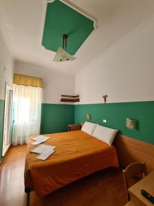 圣乔瓦尼·罗通多B&B Santa Lucia的一间卧室设有一张大床和绿色的墙壁
