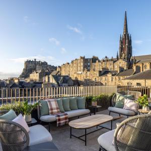 爱丁堡Virgin Hotels Edinburgh的一个带沙发和椅子的庭院,享有城市美景