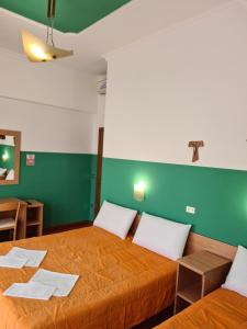 圣乔瓦尼·罗通多B&B Santa Lucia的一间设有两张床和绿色墙壁的客房