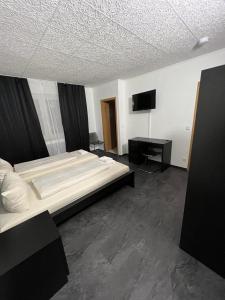 鲁尔河畔米尔海姆顿特内霍夫酒店的一间卧室配有两张床和一台平面电视