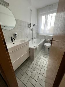 鲁尔河畔米尔海姆顿特内霍夫酒店的白色的浴室设有浴缸和卫生间。