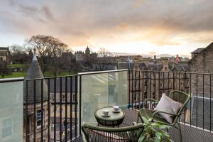 爱丁堡Virgin Hotels Edinburgh的市景阳台配有桌椅。