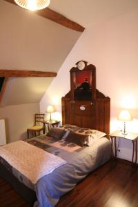 Saint-Germain-de-la-Coudre香柏乐迪德曼德劳波尼狄瑞酒店的一间卧室配有一张大床,上面有时钟