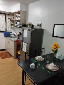 MarilaoDrea Staycation 2 Bedroom at Urban Deca Homes Marilao的厨房配有桌子和冰箱