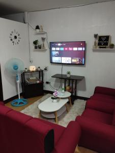 MarilaoDrea Staycation 2 Bedroom at Urban Deca Homes Marilao的客厅配有红色沙发和电视