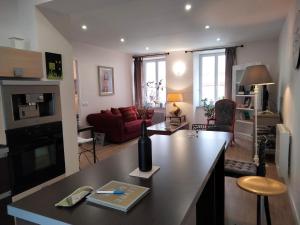 罗德兹Les Chambres Hautes d'Anastasia的一间厨房和一间带红色沙发的客厅