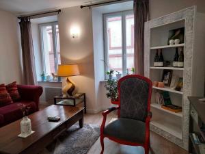 罗德兹Les Chambres Hautes d'Anastasia的客厅配有红色椅子和桌子