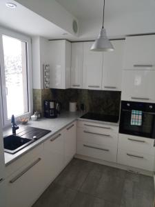 WalneDom nad Bliznem的厨房配有白色橱柜、水槽和窗户。