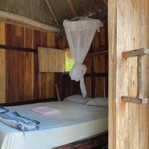 奥尔沃克斯岛Balam Camping & cabañas的小木屋内的一张床铺,配有蚊帐