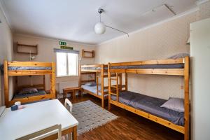 KorskrogenHovra Vandrarhem的客房设有三张双层床和一张桌子。
