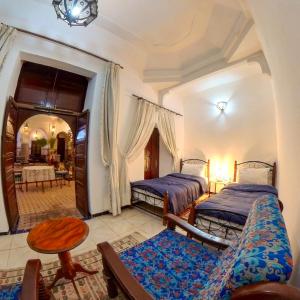 马拉喀什达尔穆莱阿里摩洛哥传统庭院旅馆的一间卧室配有两张床和一张桌子