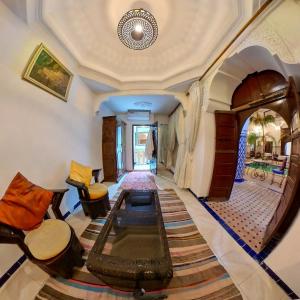 马拉喀什达尔穆莱阿里摩洛哥传统庭院旅馆的客厅配有家具和桌子。