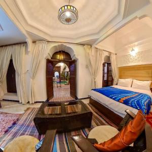 马拉喀什达尔穆莱阿里摩洛哥传统庭院旅馆的一间卧室配有一张床和一张桌子