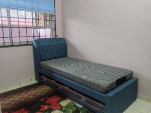 Kampong KelemakAryani Homestay的窗户客房内的一张蓝色的床