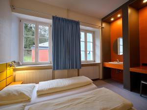 拉罗谢特拉罗谢特青年旅舍的一间卧室设有床、窗户和水槽