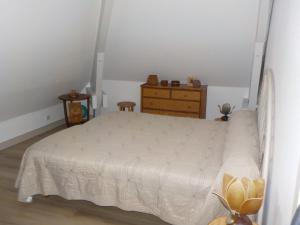 Saint-Brice-sur-VienneCHARMANT APPARTEMENT DANS MAISON DE CARACTERE的卧室配有白色的床和梳妆台。